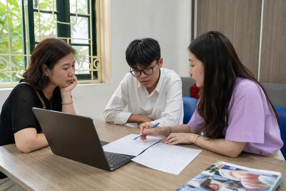 Học sinh Việt Nam cùng phụ huynh so sánh hai chương trình đại học trên tài liệu và máy tính